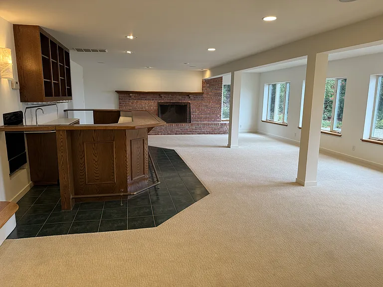 The large family room features a built-in bar featuring a mini refrigerator, sink and dishwasher.
