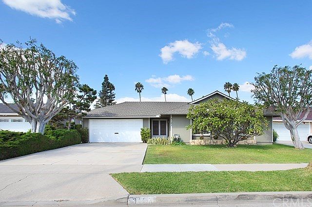 Lovely home with a beautiful plumeria tree and mid-century rock planter. The plumeria tree has been grafted with other colors and varieties of plumeria. It's Beautiful when in bloom.