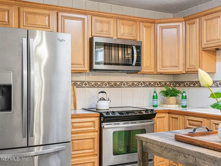 Kitchen. Connects to living room, dining, and sitting area with fireplace.