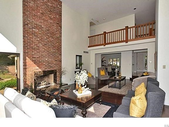 Another view of the stunning Great Room with floor-to-ceiling brick fireplace and 2nd story balcony above.