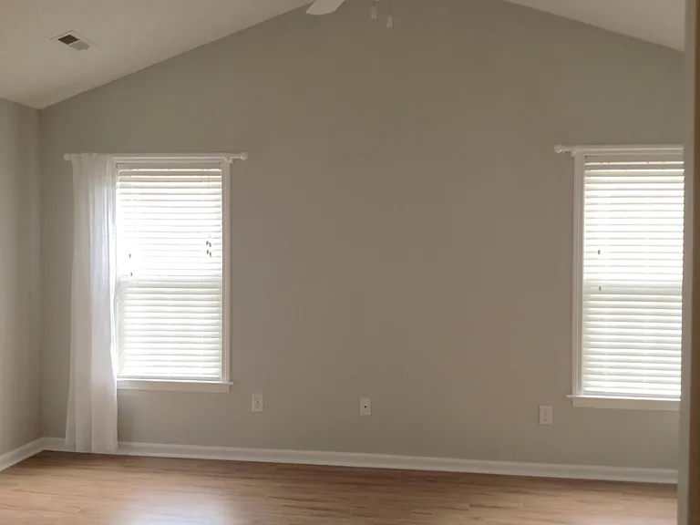 Main bedroom with vaulted ceilings, ceiling fan, privacy blinds.