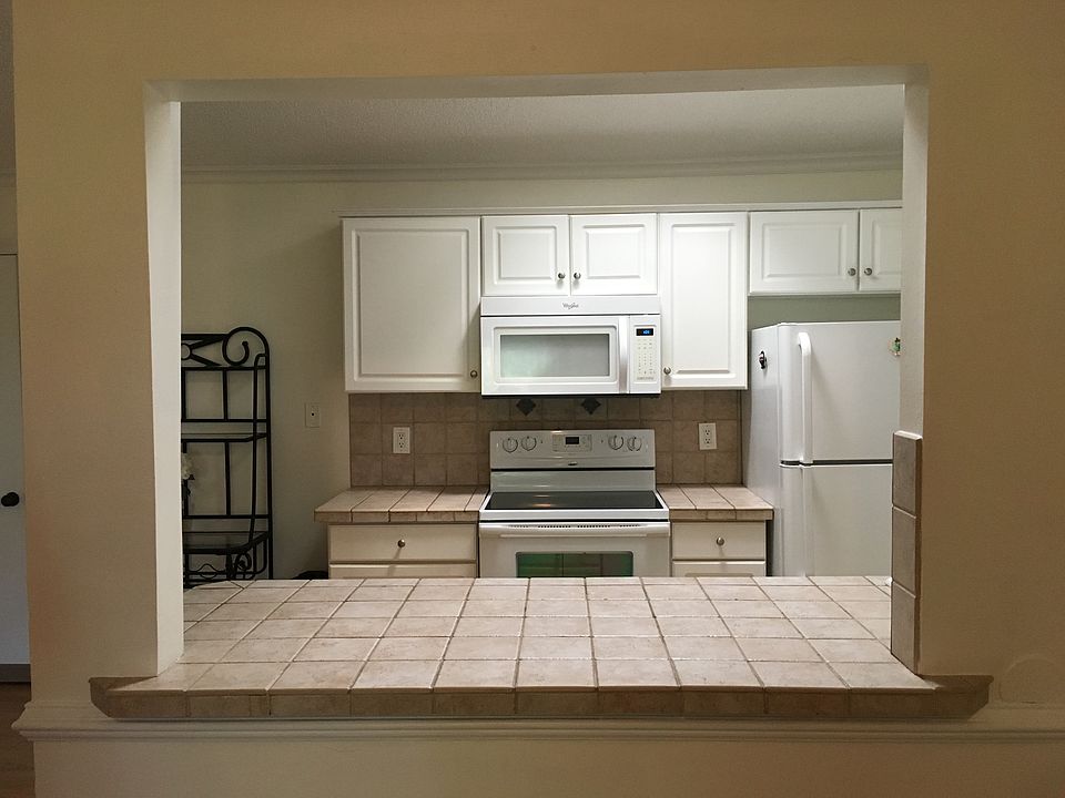 View of kitchen from bar area. Dining room to the left