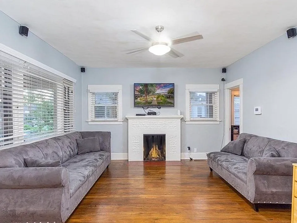 View from front door looking left into living room, hardwoods and fireplace.