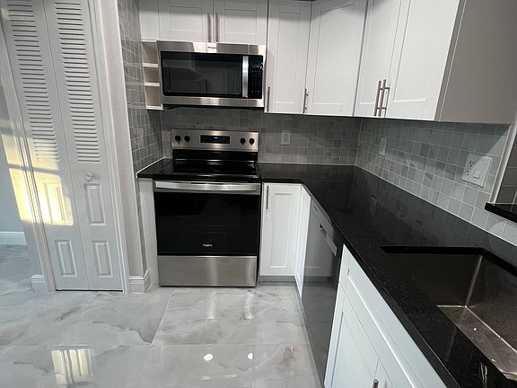 White shaker cabinets, new stainless steel appliances, and granite countertops