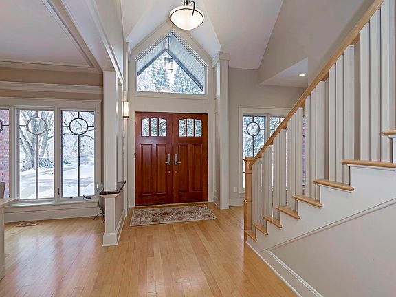 Double solid wood doors and fantastic cathedral ceiling with Hubbardton Forge pendant light bring su