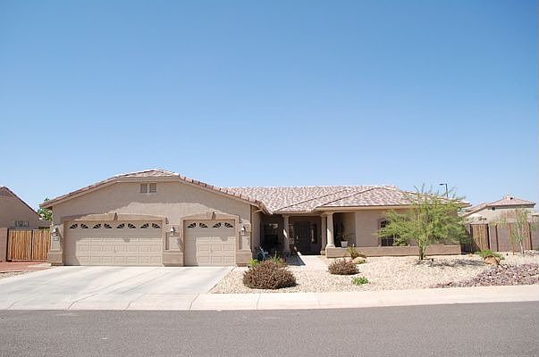 Front of home with 3 car garage and RV gate with plenty of parking