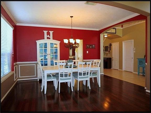 Formal dining room has custom painted wall and wood floors.