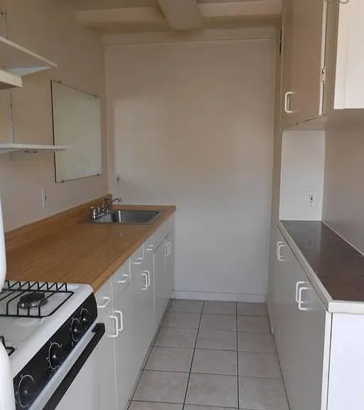 Kitchen with refrigerator and gas stove, plenty of cabinet space.