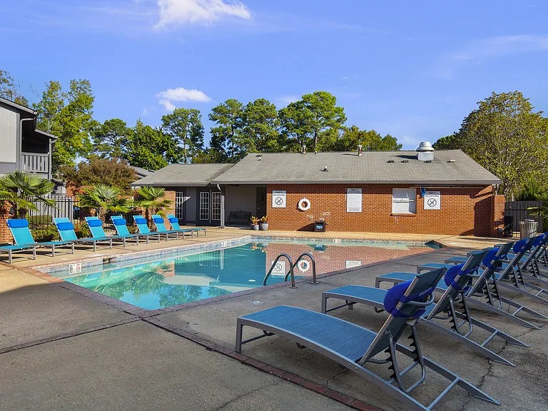 Dive into relaxation at the sparkling pool with comfortable seating at Lakeland East Apartments in Flowood, MS. Managed by Highlands Vista Group.