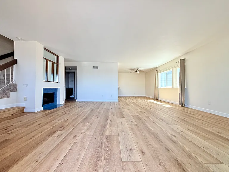 Wide angle view of lower level with new luxury vinyl plank flooring.