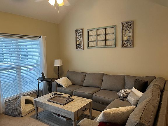 Large living room with ceiling fan and front-facing window