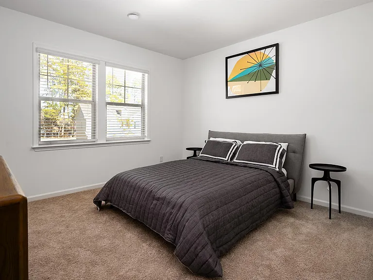 Secondary bedroom with queen size bed and large window letting in a ton of natural light.