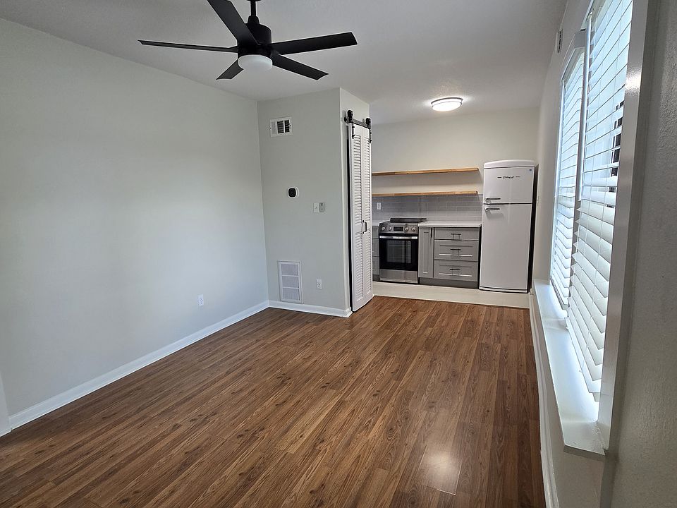 Main living area with ceiling fan and two windows, cable