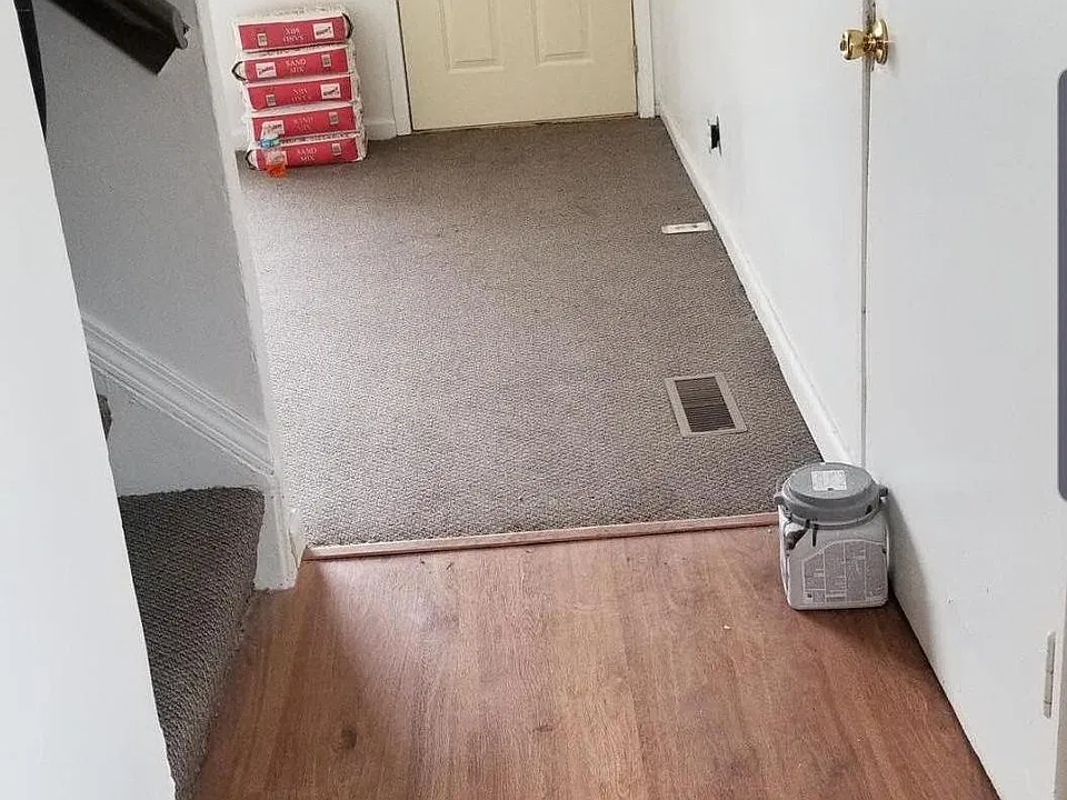 Hall area coming from kitchen leading up stairs and to the living Room and front door..