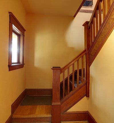 A beautiful foyer entry has been restored and the staircase leads to the second floor apartment with