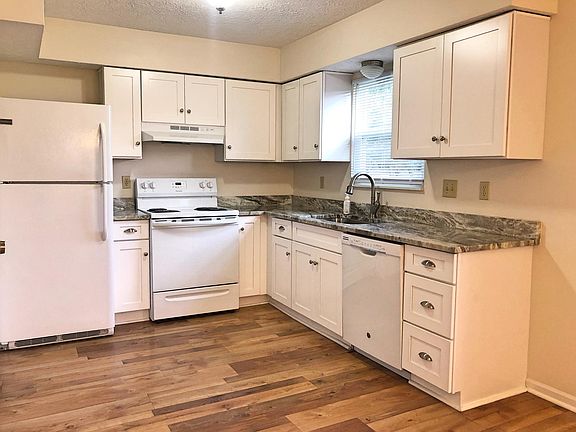 Remodeled kitchen with granite countertops, white cabinetry, and updated appliances. Brand new range!