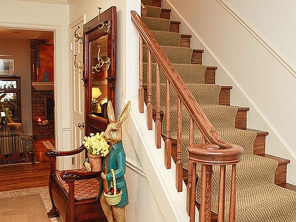 The front entry hall features a wood staircase to the 3 bedrooms upstairs.