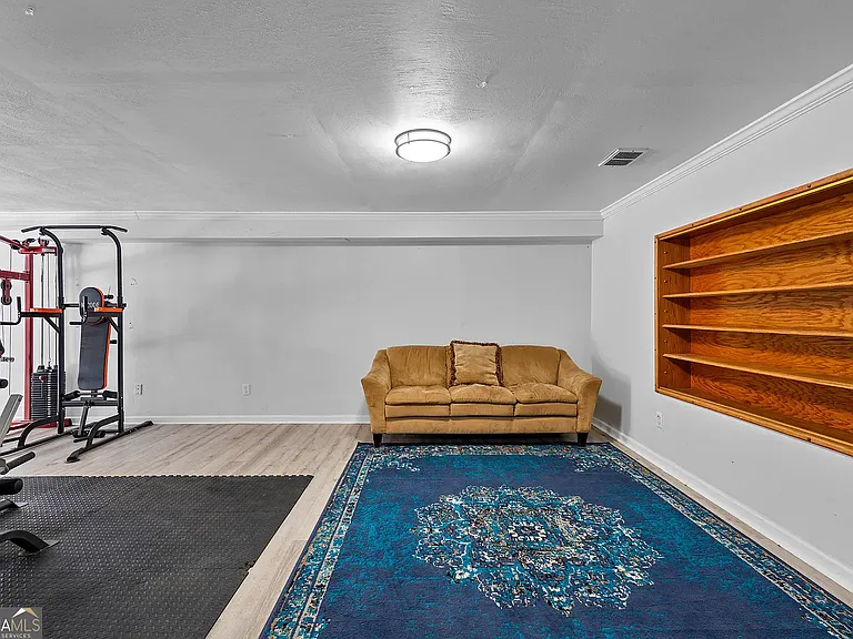 Finished basement with shelving and multiple storage closets