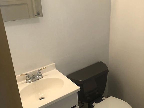 Vanity and Toilet. Shower is visible in the mirror.