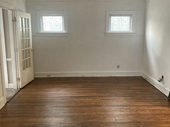 other view of living area with hardwood floors and decorative windows