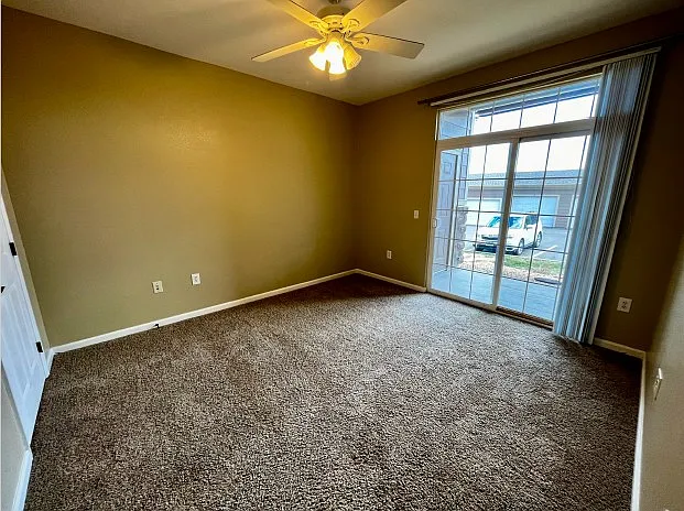 First bedroom with sliding glass door leading to porch.