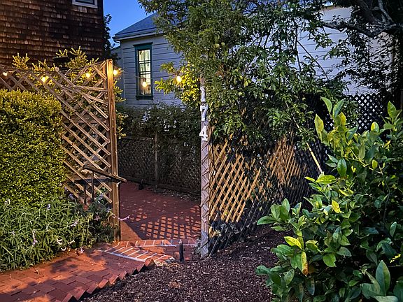 Night view of apartment entrance, with plum and pear trees to the right