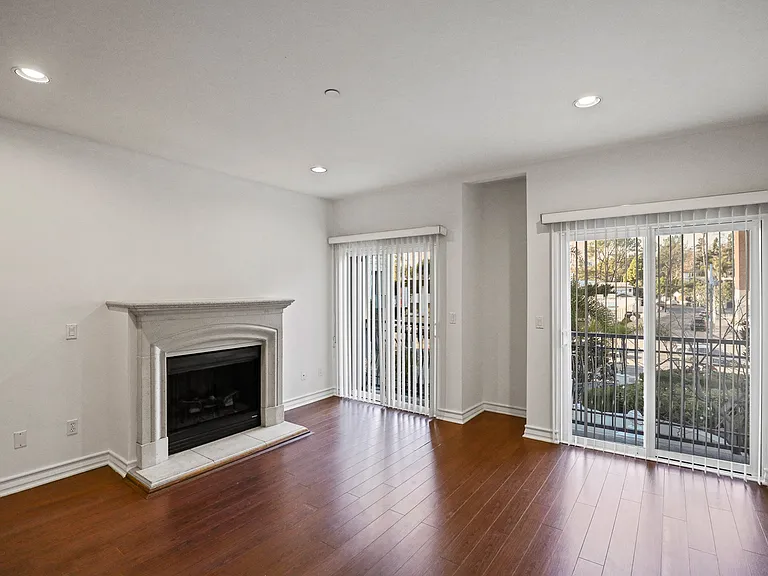 Living Room Area with an Electric Fireplace, Vinyl Flooring, and Balcony