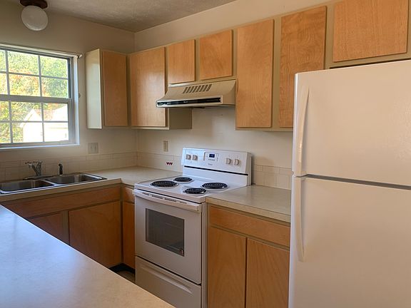Kitchen showing self cleaning oven and refrigerator with ice maker and plenty of cabinet and drawer storage.
