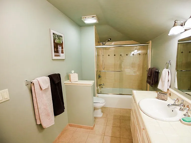 Nice thoughtful touches, soothing spa colors, and plenty of light for a comfortable shared bathroom experience.
