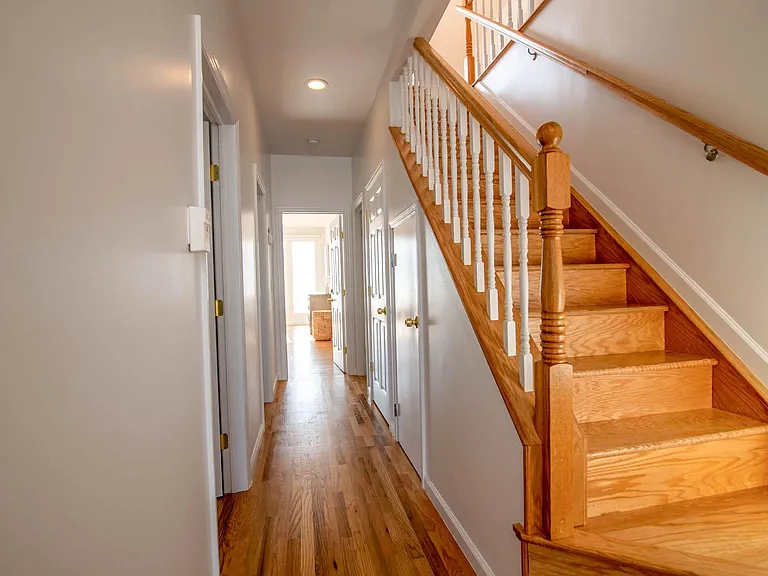 Second floor hallway leading to additional bedrooms, bathrooms and closet with washer and dryer. Staircase to 3rd floor.