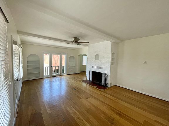 Living room. Front door on left across from fireplace. The far door opens to a small balcony.