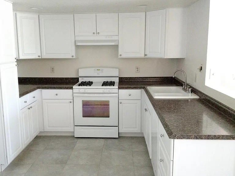 Kitchen features a stove/oven, refrigerator, dishwasher, garbage disposal, and ample cabinetry.
