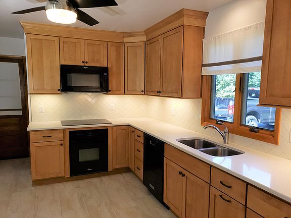 New kitchen with quartz countertop and tile backsplash and floor