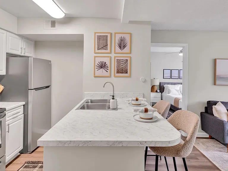 Our kitchens feature a seamless breakfast bar, with stunning white Carrara countertops, creating a bridge between the kitchen masterpiece and the inviting living space.