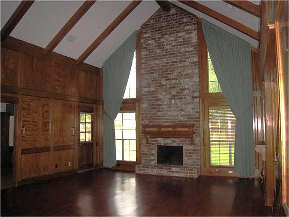 Den with High Ceiling Beautiful Block paneling.  Carpet recently installed. (replaced laminate wood floor) *not reflective on this photo