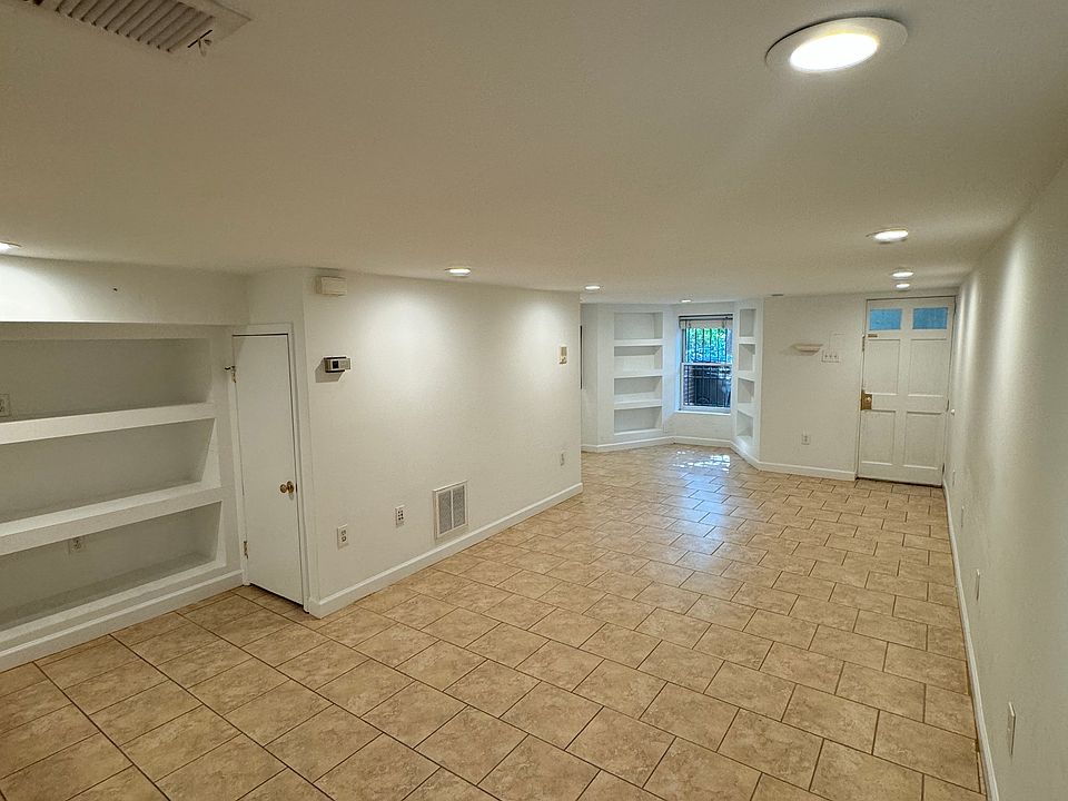 View of living room, complete with built in shelving.