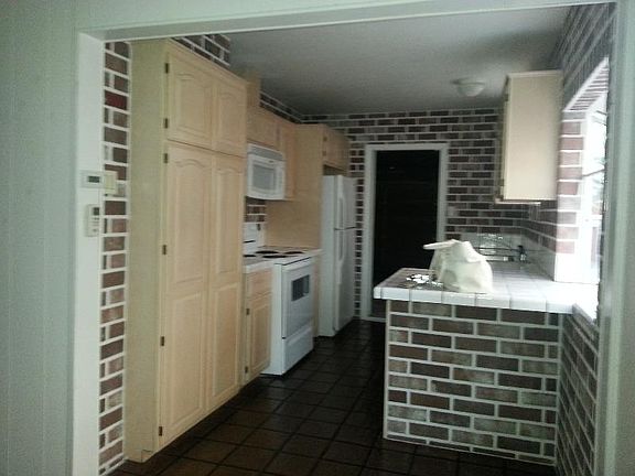 Galley kitchen with rustic brick detail