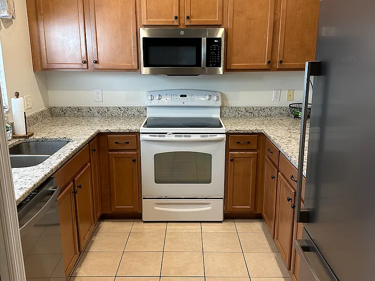 Old picture - Kitchen with updated stainless steel appliances (dishwasher, microwave, range and fridge). New granite countertops installed in 2022.