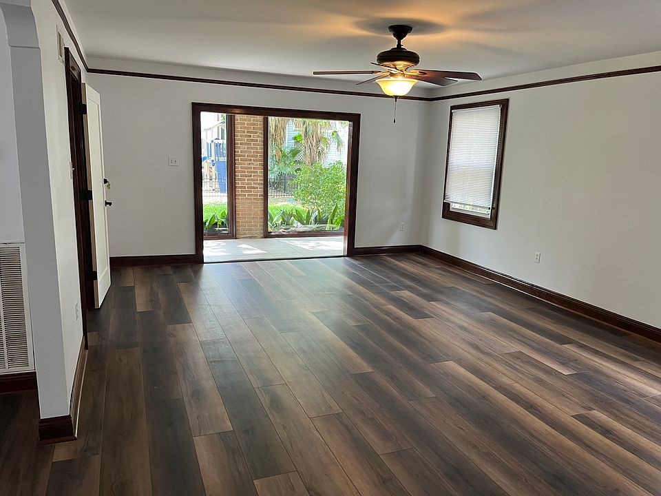 Large living room with new floors looking towards sunroom.