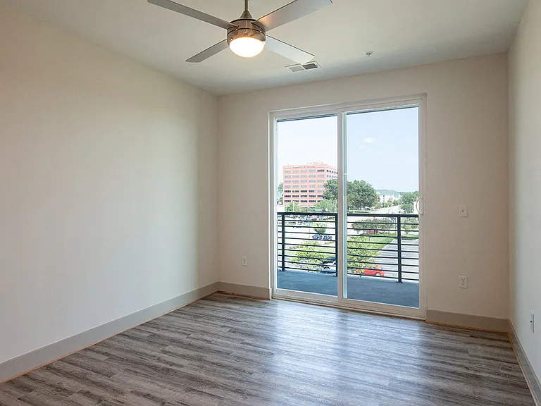 Ceiling fans, floor to ceiling windows and plank wood finish floors