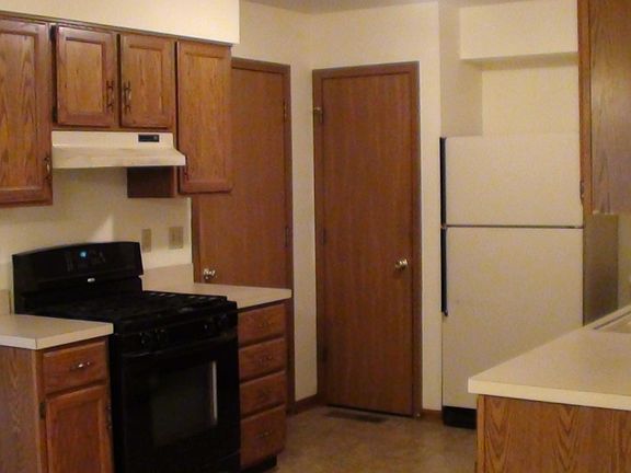 Kitchen showing range, door into garage and pantry door