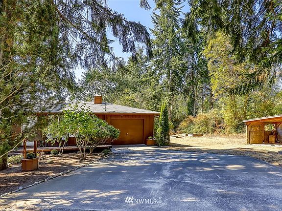 The home is set back from the road with plenty of room for parking in front.  Covered storage area seen on right. 
