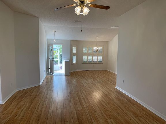 View from living room toward front door. Enjoy meals in the spacious dining room with wall of windows overlooking front porch and yard. Easy to maintain laminate flooring.