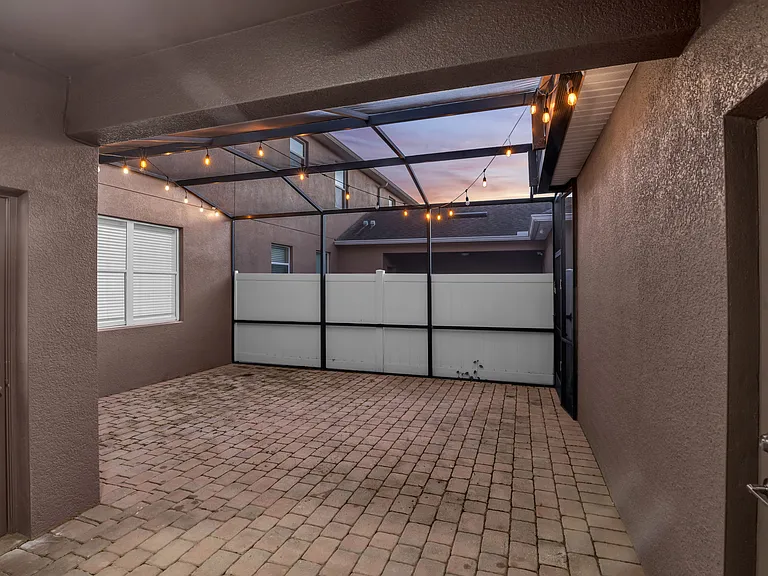Spacious screen enclosed patio with covered walkway to detached 2 car garage