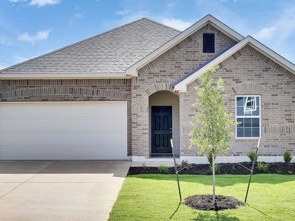 Experience classic elegance with a brick facade and meticulously landscaped garden in Avalon at Hunt