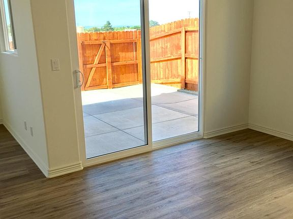 Dining area has a chandelier, with a glass sliding door that opens to a concrete patio.