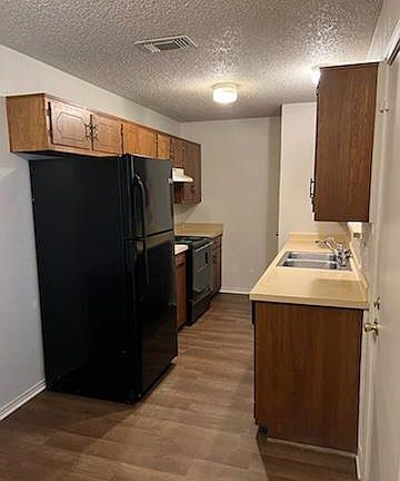 Galley Kitchen with Refrigerator, Electric Stove, dishwasher, and pantry.