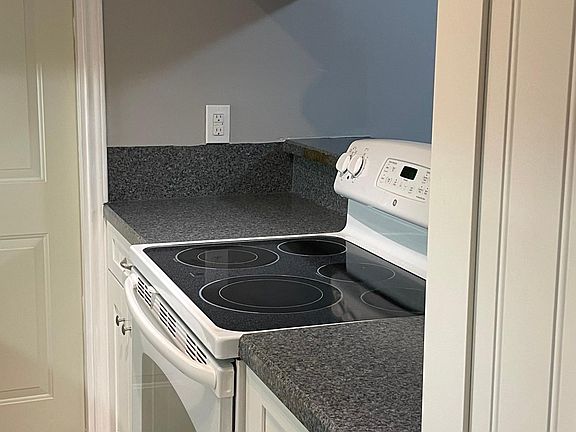 Tile floored kitchen with updated appliances and cabinetry.