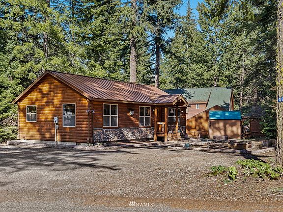 Rustic log and river rock siding tucked into the mature growth of the surrounding evergreen trees.  