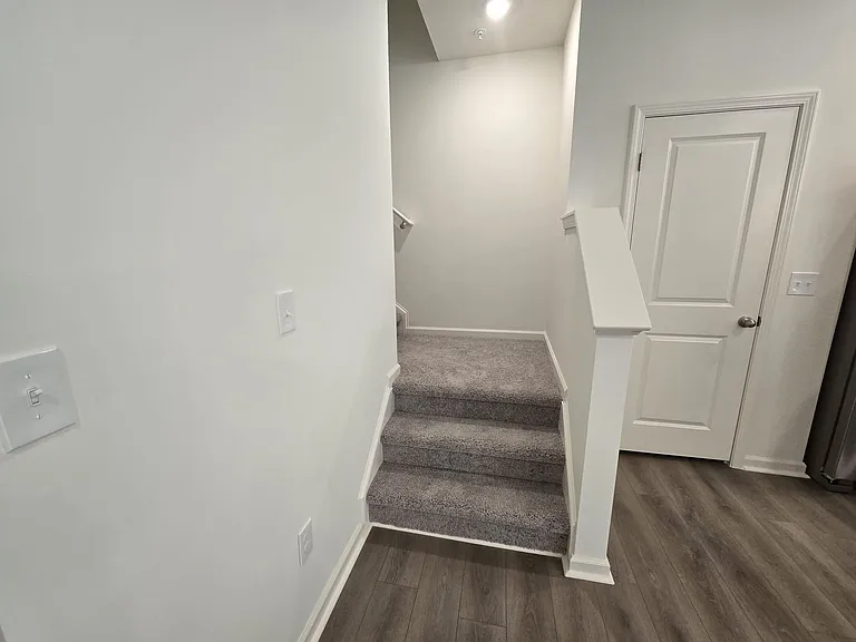 carpeted stairs from 1st floor to 2nd floor with a landing area
